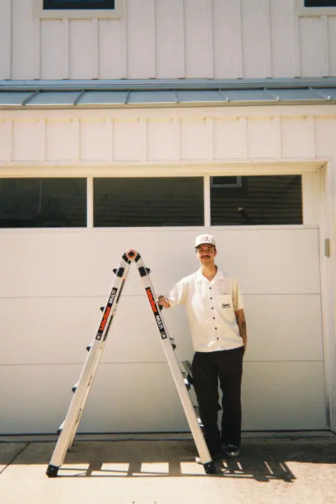 Keagen standing beside a ladder after residential window service