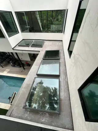 Modern estate courtyard with large skylight glass and exterior windows after washing