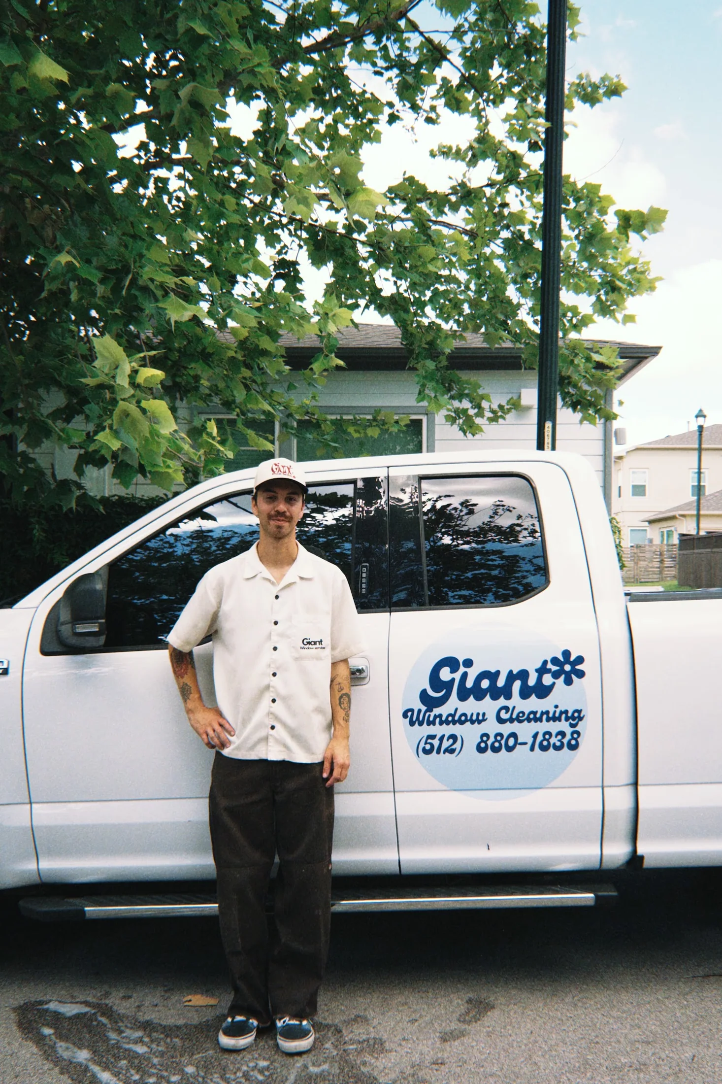 Keagen standing by the branded Giant Window Cleaning service truck in Austin