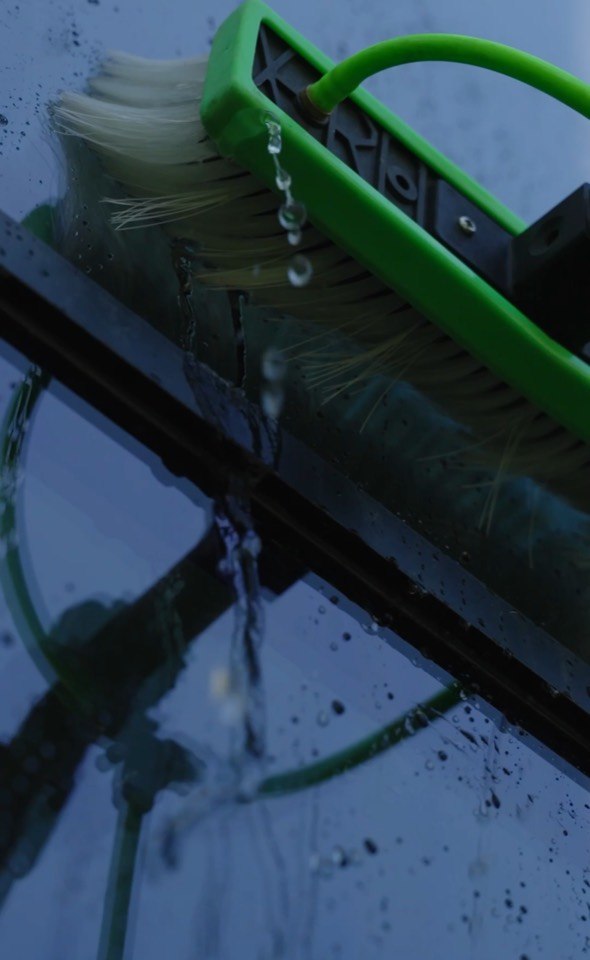 Water-fed brush washing exterior window glass during a Giant Window Cleaning job